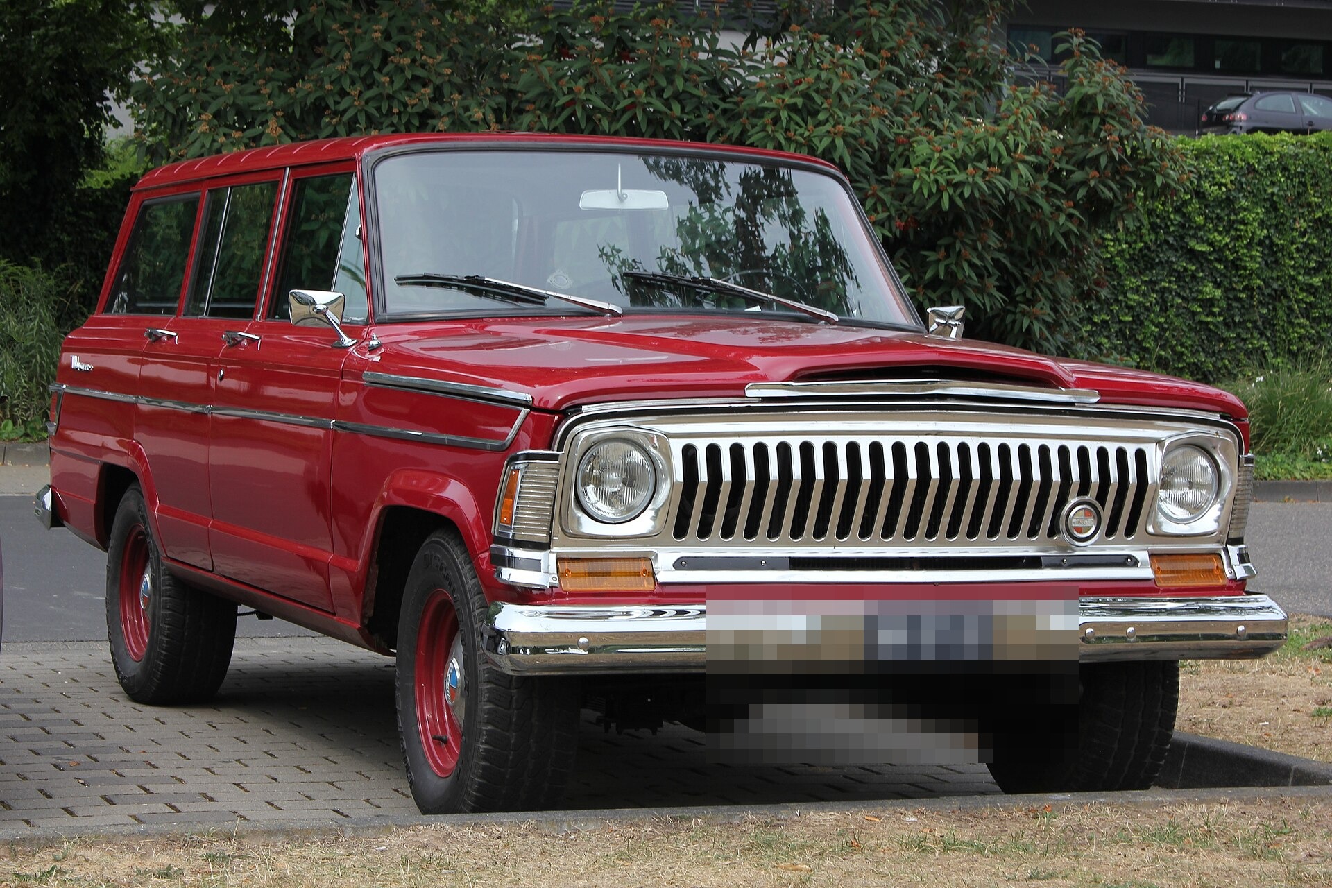 A late-1960s Jeep Wagoneer SJ seen from the front three-quarter angle
